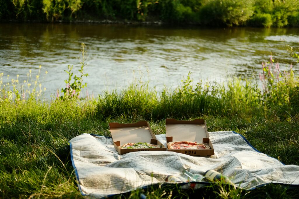 A blanket is set up on the bank of a river
